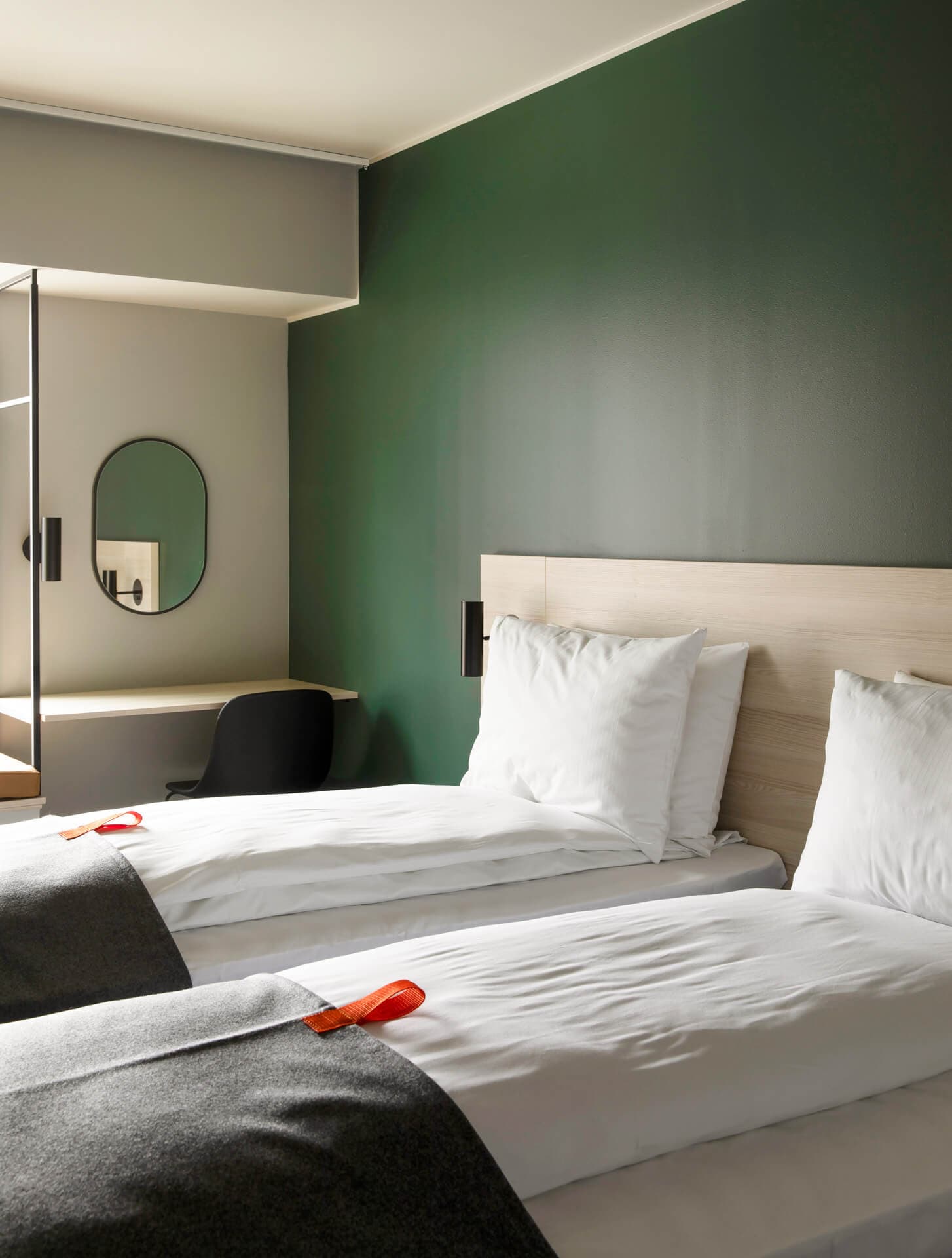 Twin beds, desk, mirror, chair, green wall